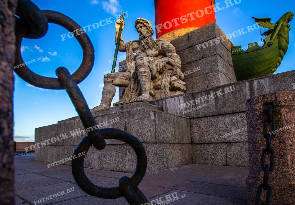 Фотография показывает одну из скульптур у Ростральных колонн на Стрелке Васильевского острова в Санкт-Петербурге. 
Это изображение может быть использовано в исторических обзорах, культурных статьях и путеводителях, демонстрируя искусство и архитектурное наследие города.